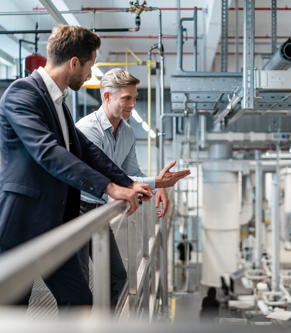 Two businessmen talking in a modern factory